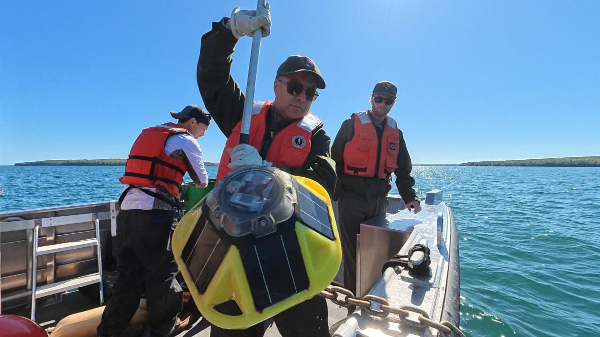 Eric Eppensteiner brings one of the buoys on board - Jon Okerstrom photo