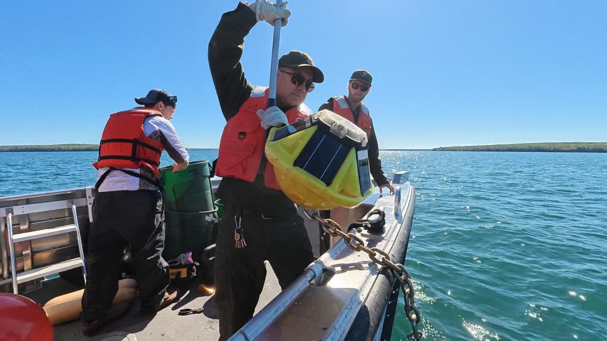 Eric Eppensteiner brings one of the buoys on board - Jon Okerstrom photo